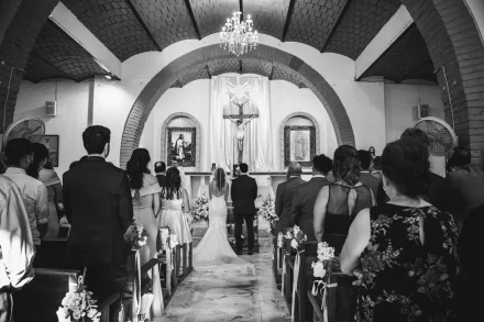 A timeless moment of solemnity and grace captured in black and white. Standing at the altar before their family and friends, the bride and groom exchange sacred vows in an atmosphere filled with reverence and love in Puerto Vallarta