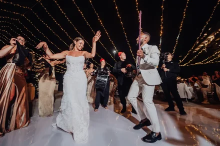 High energy, vibrant rhythms, and unstoppable celebration. The bride and groom take over the dance floor under a canopy of twinkling lights, dancing alongside live drummers during an unforgettable wedding reception in Puerto Vallarta