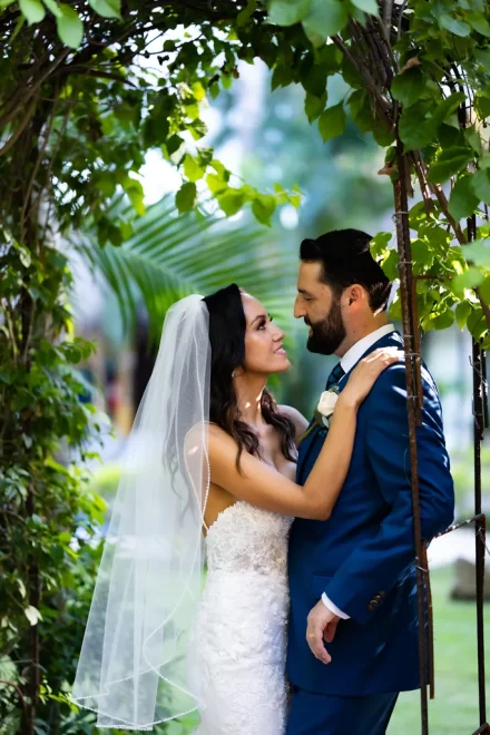 A sweet, intimate gaze framed by lush natural leaves. Wrapped in each other's arms, the couple captures a peaceful and deeply tender moment together in Puerto Vallarta
