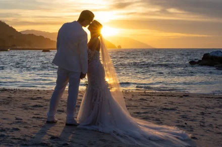 As the sun dips below the horizon, creating a glowing frame around their embrace. A timeless silhouette etched against the ocean, capturing romance and quiet magic in its purest form