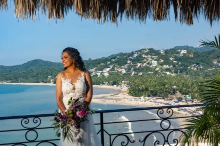 Standing high above the coast with endless blue waters stretching into the horizon, the bride glows with radiant joy. A captivating moment that perfectly blends natural coastal beauty with pure wedding romance in Puerto Vallarta