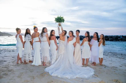 Capture that perfect moment of pure joy: your closest friends looking back, sharing a laugh as you hold your caught bouquet high. An unforgettable memory made in the magical golden hour light