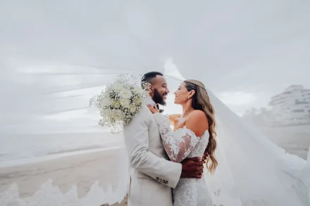 An intimate world built for two amidst the ocean breeze. Softly framed by the delicate sway of her floating veil, the newlyweds hold each other close, sharing an unforgettable moment of tenderness on the beach in Puerto Vallarta