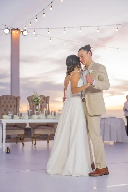 The world fades away during your first dance as husband and wife. Swept up under warm string lights and a soft twilight sky in Puerto Vallarta, this tender moment encapsulates pure romance and the timeless bliss of starting your forever journey