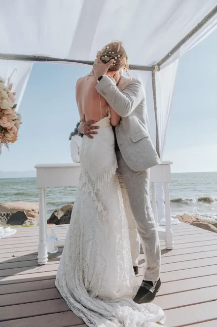 The world stands completely still for the first kiss as husband and wife. Framed by a delicate oceanfront gazebo and the endless blue horizon, this intimate, passionate embrace captures the magic of saying 'I do' in paradise
