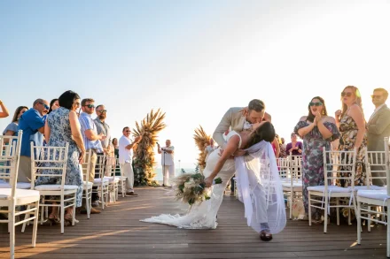 A dramatic dip and a passionate kiss to seal their walk down the aisle. Surrounded by cheering family and friends in the golden coastal sunlight, this unforgettable moment captures the spontaneous romance and pure magic of a Puerto Vallarta wedding
