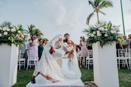 A romantic dip and kiss that captures all the joy of walking down the aisle together as newlyweds. Framed by elegant white floral arrangements and cheering family and friends, this unforgettable moment radiates celebration and love in Puerto Vallarta