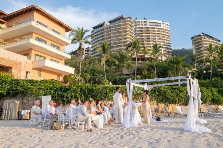 Saying 'I do' to the soothing sound of ocean waves in a breathtaking tropical paradise. An intimate yet sophisticated ceremony where soft white sand, elegant drapery, and stunning resort views come together to create your dream wedding setting