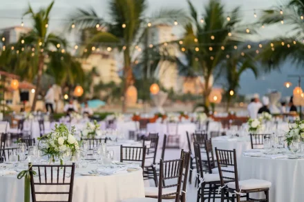 A dreamy atmosphere crafted to welcome the happiest night of your life. With refined floral centerpieces, classic seating, and the warm glow of string lights against the tropical dusk, this outdoor reception setting in Puerto Vallarta creates an enchanting backdrop for an unforgettable celebration under the stars