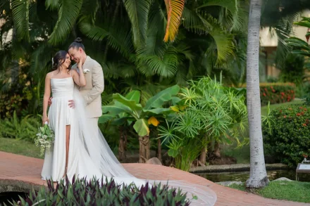 A glance that speaks volumes and a gentle touch that makes time stand still. Nestled among tropical pathways and vibrant palm leaves in Puerto Vallarta, this tender moment captures pure devotion and the serene joy of holding the one you love