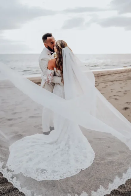 A breathtaking romance captured in motion. As the gentle ocean breeze catches her long, flowing veil across the sands, the couple shares an intimate kiss on the shores of Puerto Vallarta