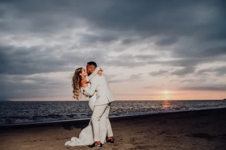 A breathtaking romance under the golden hues of twilight. As the sun sets over the ocean horizon, the newlyweds embrace in a passionate kiss along the peaceful beach of Puerto Vallarta