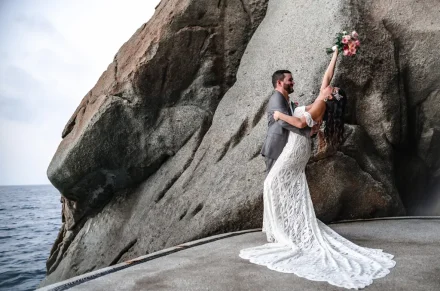 Pure joy and playful celebration wrapped in one breathtaking moment. Dipping into forever amidst the majestic coastal rocks, holding your bouquet high—this is the uninhibited excitement of saying 'I do' in Puerto Vallarta