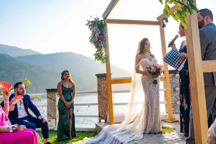 Hearing the words that bind two hearts forever, framed by the gentle light of a setting sun and the majestic beauty of Puerto Vallarta's cliffs. The joyful anticipation is captured in the bride's eyes and the quiet attention of loved ones, creating an unforgettable memory of love and devotion