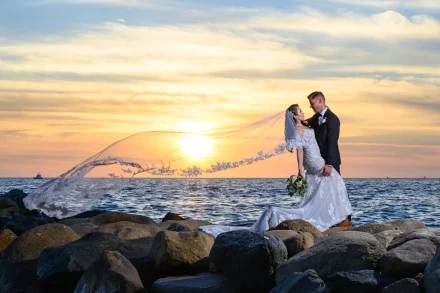 Swept away by the romance of the Pacific. As the sun dips below the horizon in vibrant golden hues, a dramatic long veil floats effortlessly over the waves, capturing a breathtaking moment of passion and elegance in Puerto Vallarta