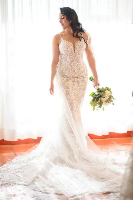 A vision of grace and effortless beauty. Wrapped in intricate lace and bathed in soft, natural window light, this bridal portrait captures the quiet confidence and breathtaking elegance of a bride ready to say 'I do' in Puerto Vallarta