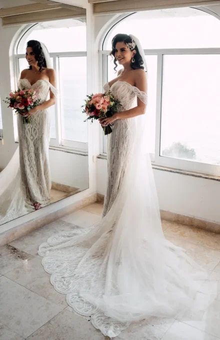 The breathtaking moment when it all comes together and you see yourself as a bride for the very first time. Radiating confidence and timeless grace, every detail—from the intricate lace train to the soft coastal light—creates an unforgettable prelude to saying "I do" in Puerto Vallarta