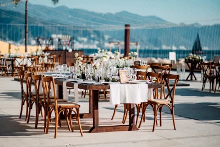 An invitation to celebrate in paradise. Surrounded by sweeping views of the bay and mountains, these beautifully set outdoor reception tables set the scene for an unforgettable evening of fine dining and heartfelt toasts in Puerto Vallarta