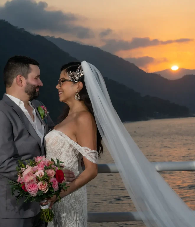 Bathed in the warm, golden glow of a Pacific sunset, this tender gaze speaks louder than words. As the sun dips behind the majestic mountains, your love story shines brightest, leaving you with an unforgettable moment frozen in time in Puerto Vallarta