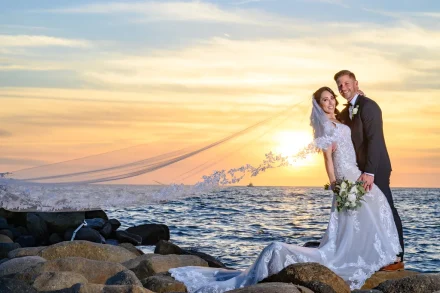 Bathed in the warm golden light of a spectacular Pacific sunset. Embracing on the rocky shoreline as the long veil catches the gentle ocean breeze, this romantic portrait captures the dreamy, timeless essence of sunset love in Puerto Vallarta